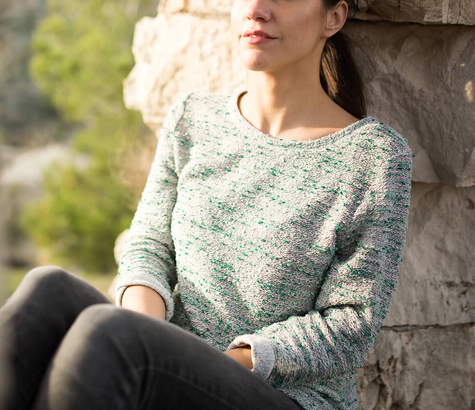 Image of a peaceful woman leaning against a rock wall. If you struggle with an eating disorder and are looking for support, discover how a skilled eating disorder recovery coach in the United Kingdom can help you cope.