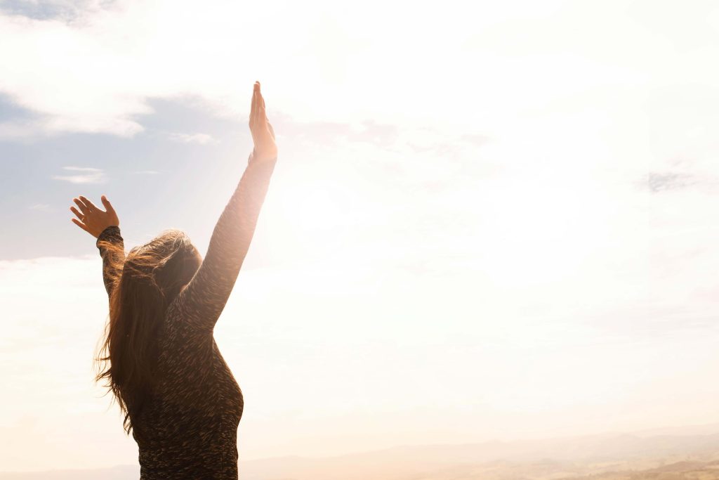 woman raising hands | eating disorder recovery coaching in the uk | eating disorder recovery coach | eating disorder coaching | meal support | England | Scotland | Ireland Image of a happy woman standing outside with her arms raised in the air. Navigate the tough moments that come with an eating disorder with the help of an eating disorder recovery coach in the UK.