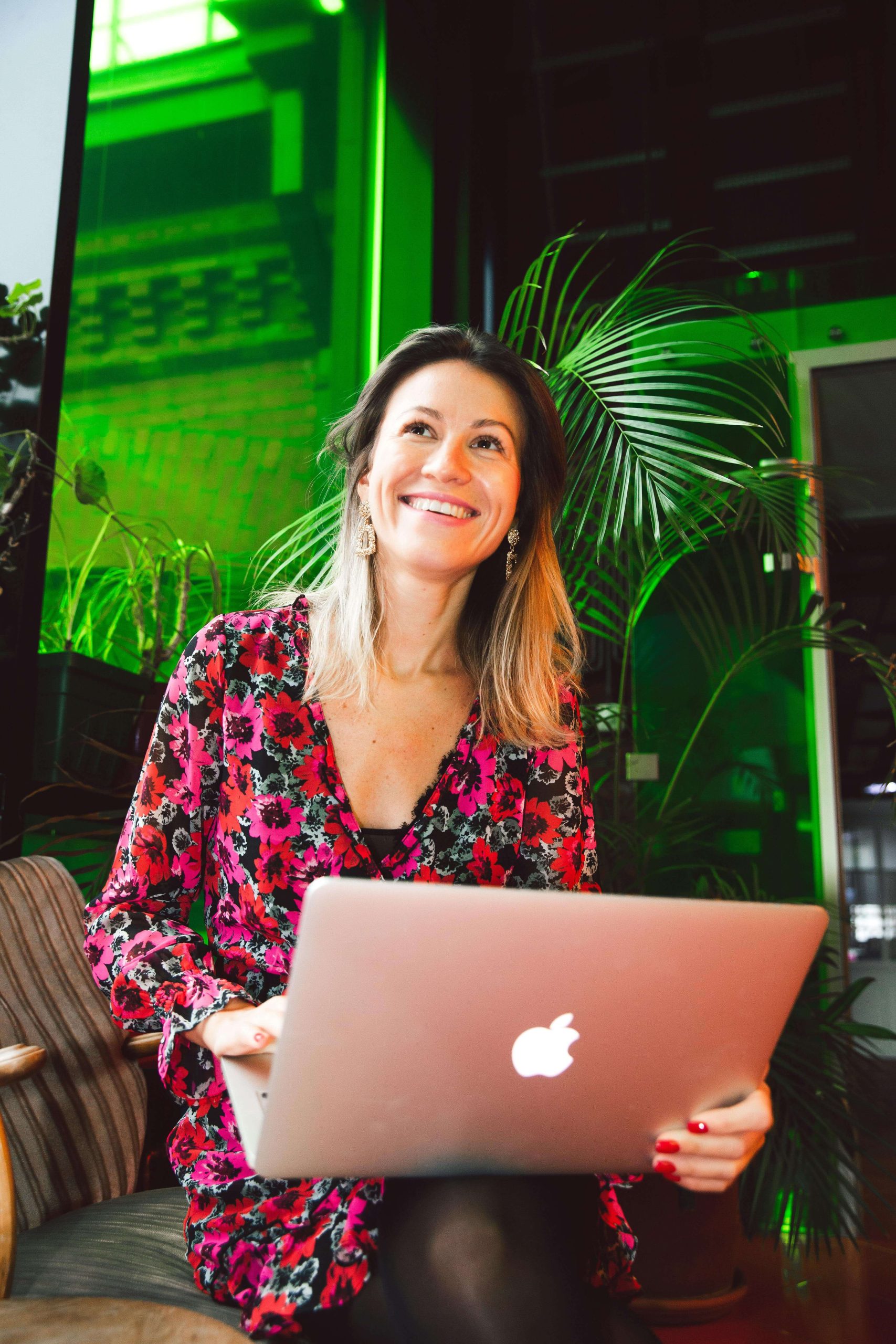 Smiling woman sitting in a chair holding a laptop on her lap. With the collaboration of an eating disorder recovery coach in the UK and your medical provider, you can begin recovering with support.