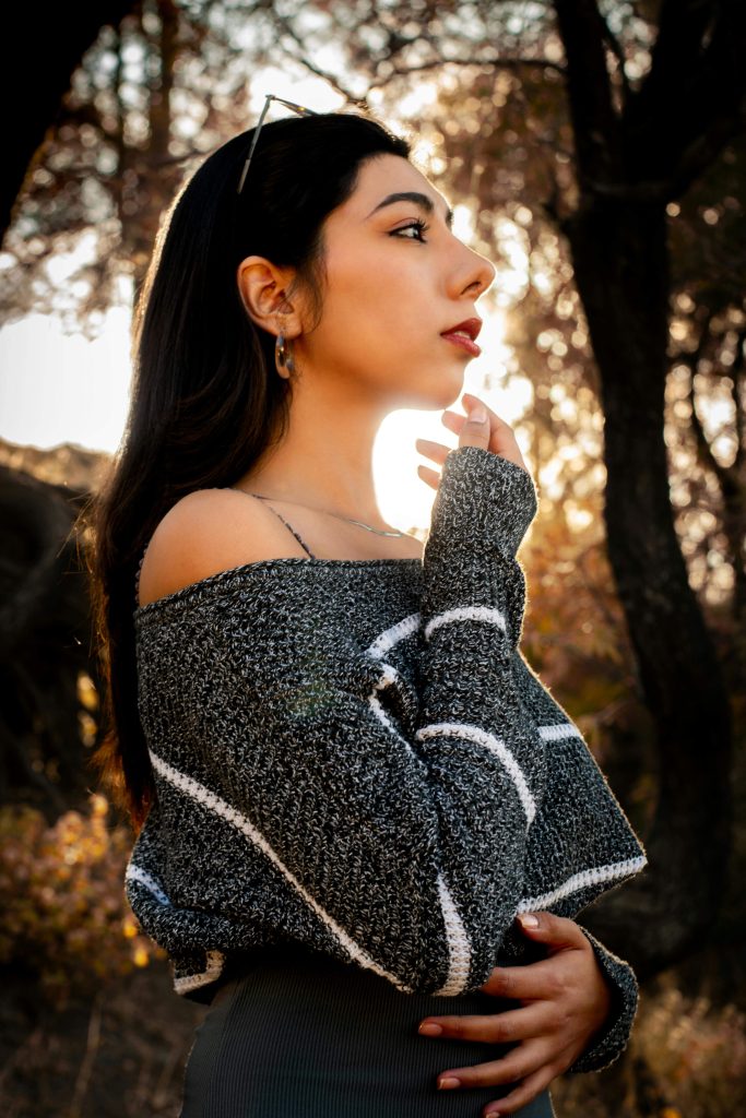 woman in striped sweater at sunset | eating disorder recovery coaching | eating disorder recovery coach | anorexia coach | England | Ireland | Scotland A young woman wearing a gray and white striped sweater gazes thoughtfully into the distance as the sun sets behind her. Take the first step toward healing from anorexia with the help of an eating disorder recovery coach in England, finding strength through eating disorder recovery coaching and anorexia recovery support.