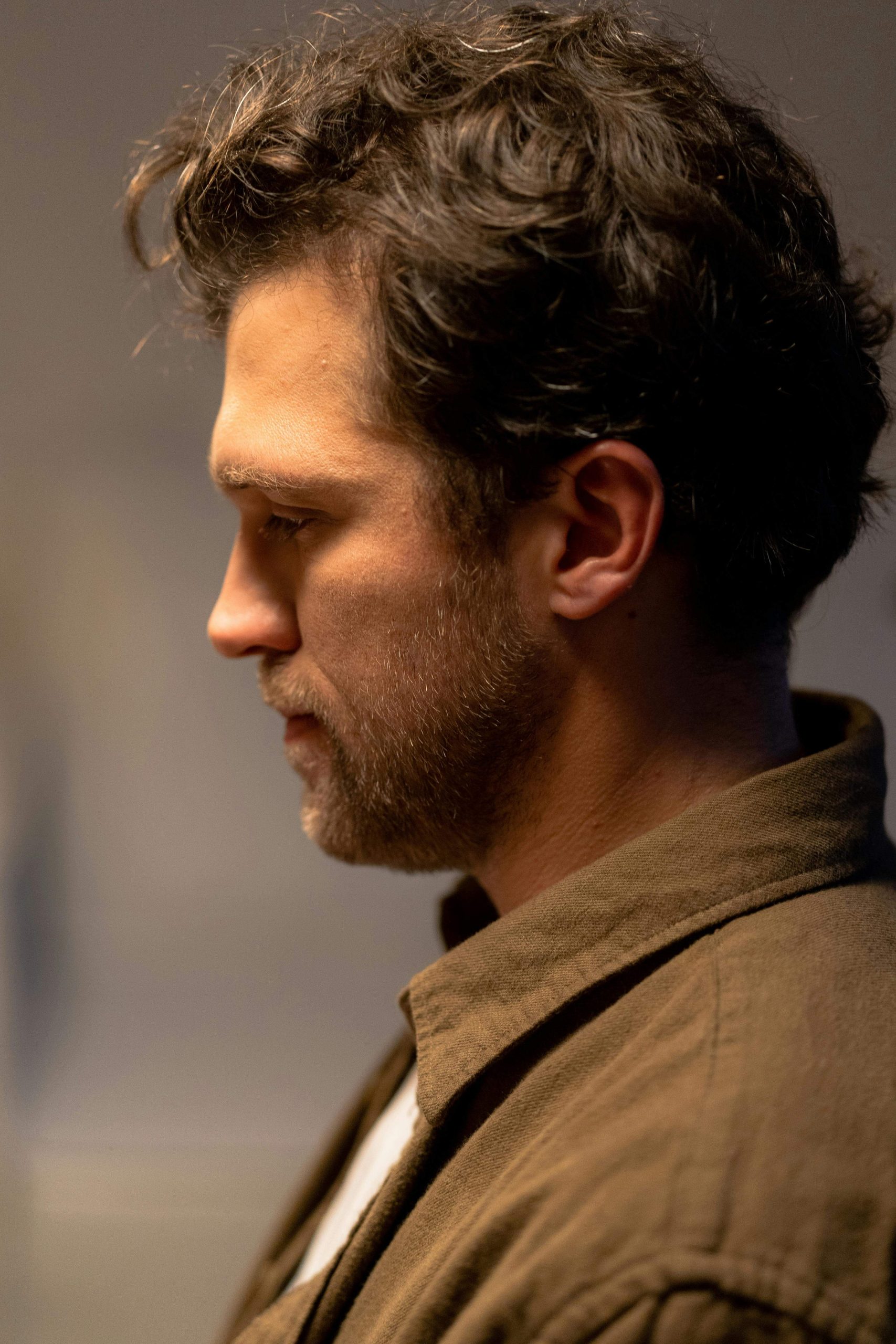 Side profile of a man with a beard looking thoughtful. A British eating disorder recovery coach can support you in rebuilding body trust and healing your relationship with food.
