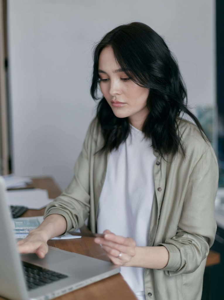 Woman working on a laptop at a desk. Reconnect with your body’s signals and rebuild trust through eating disorder recovery coaching in England.